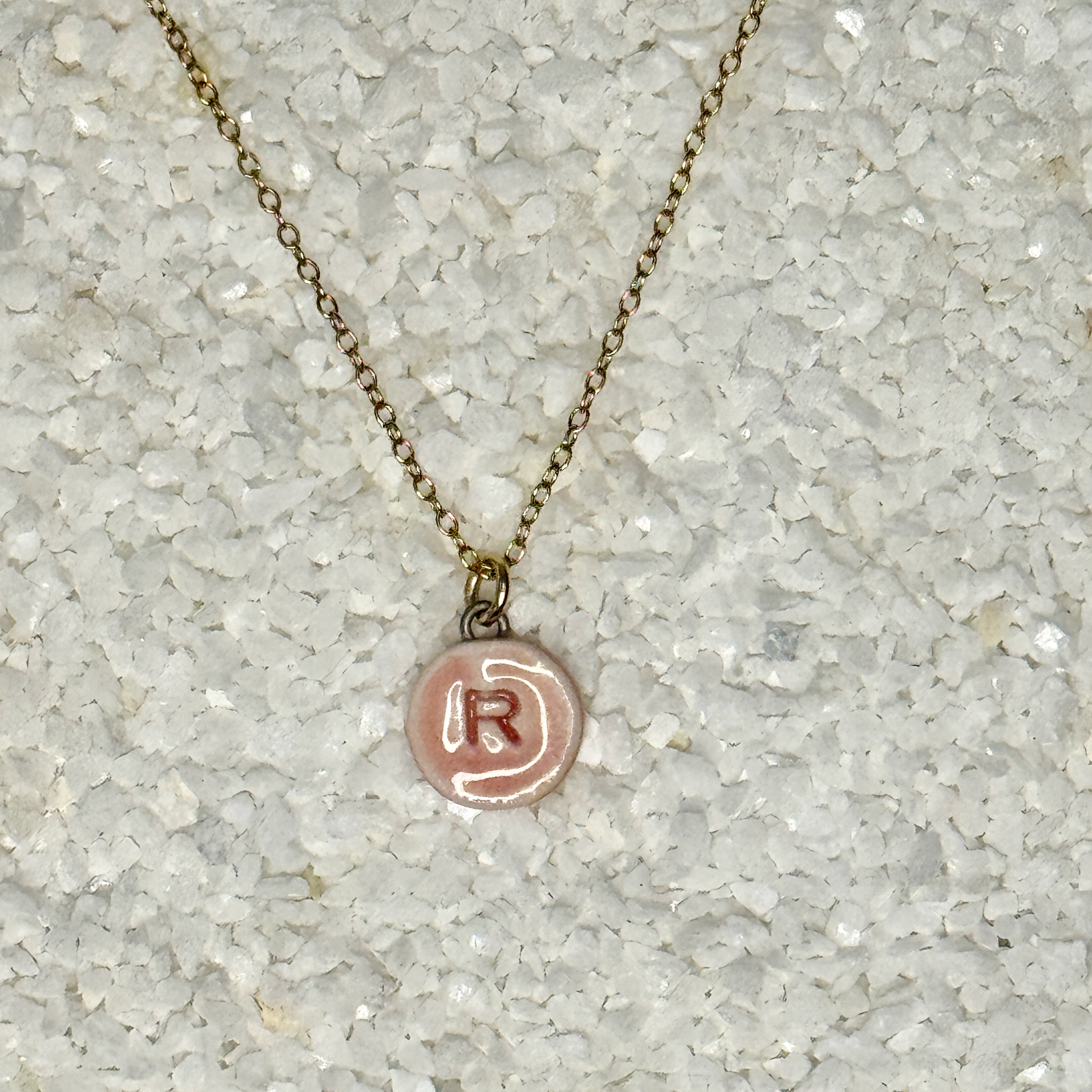 small circular light pink letter charm necklace