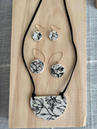 floral necklace and earrings set on a wood board