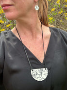 woman wearing black shirt and black and white floral necklace